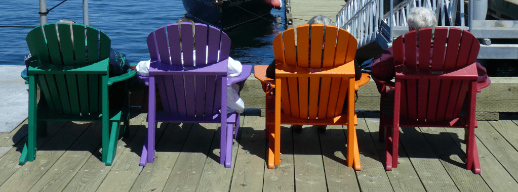 Picture of four brightly coloured deck chairs in a row.